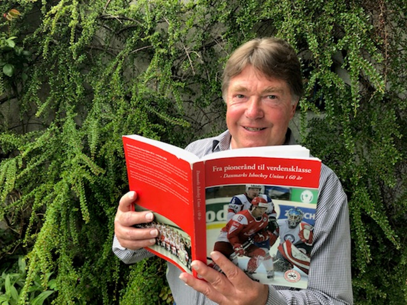 Carsten Nielsen hygger sig under coronakrisen med hockeybiblen ”Fra pionerånd til verdensklasse”, som udkom i 2009. Foto: Peter Fredberg