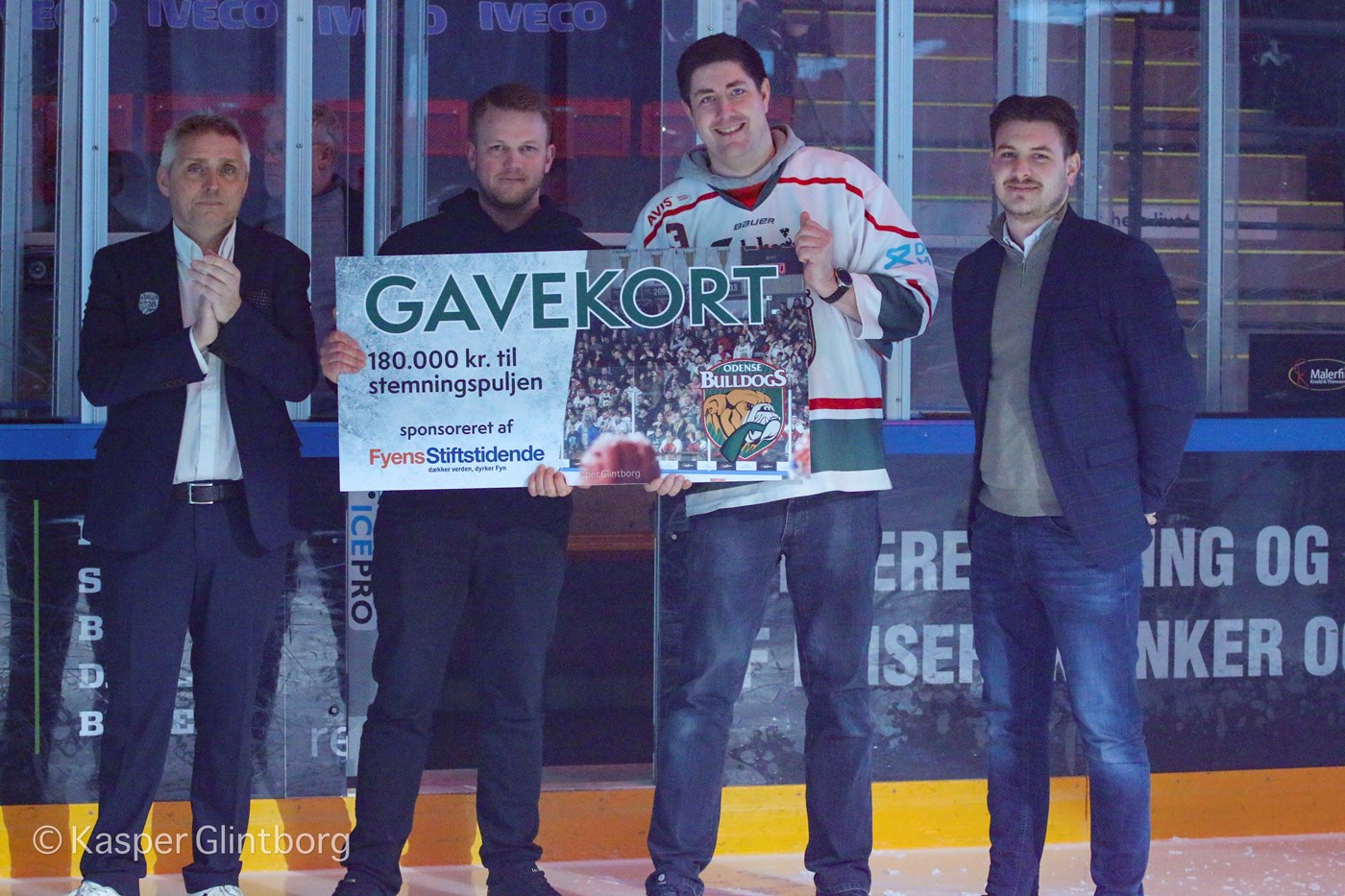 Gavekort på 180.000 kr. til stemningsskabende aktiviteter overrækkes af Mads Juncher fra JFM. Fra venstre: Jacob Landtved (Odense Bulldogs) , Nicolai Mark Zerny (Topdogs), Nicolaj Hansen (Odense Bulldogs Support), Mads Juncher (JFM).