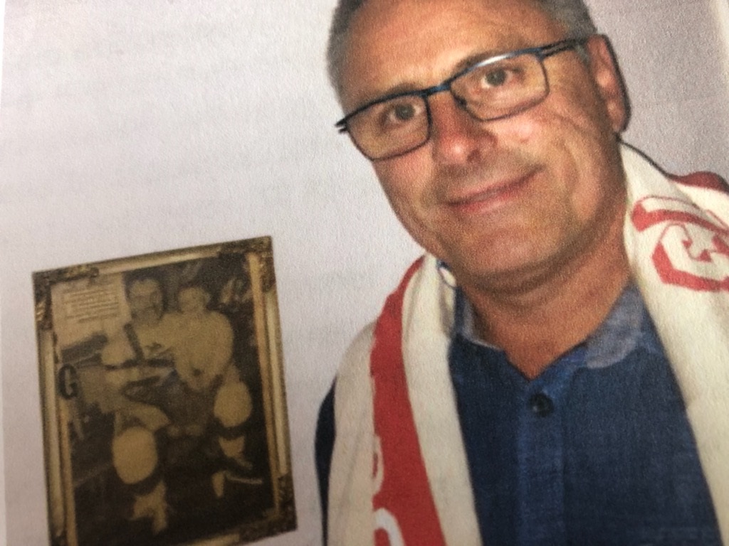 Kim med tre-årige Sebastian på knæet på avisudklippet i glas og ramme på væggen.