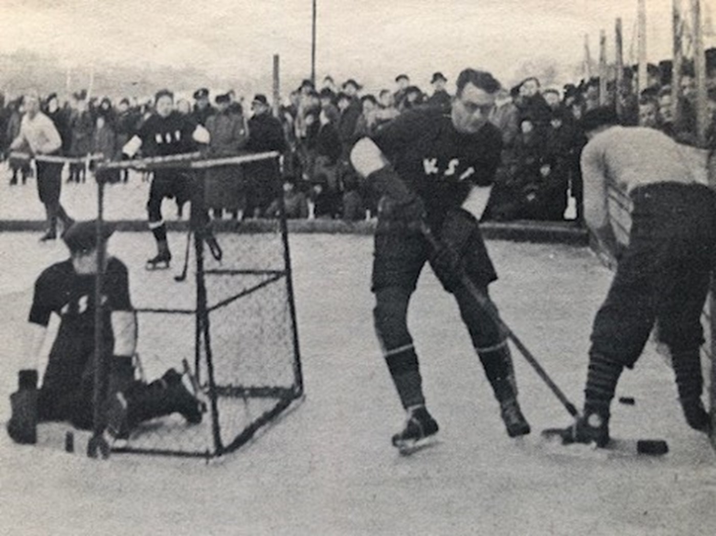 Ishockey i de gode, gamle dage på Peblingesøen i København. Situationen er fra en kamp mellem KSF og et svensk hold i 1929. Læg mærke til de lave bander, spillernes ringe beskyttelsesudstyr og de mange tilskuere.