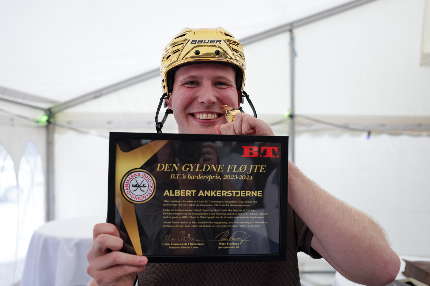 Albert Ankerstjerne kan sagtens være glad. Her er han med B.T.s Gyldne Fløjte, guldhjelmen og diplom. For andet år i træk blev han kåret som årets ishockeydommer. Nu drømmer han om OL. Foto: Danmarks Ishockey Union